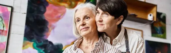 Two women admire paintings in art studio. — Stock Photo