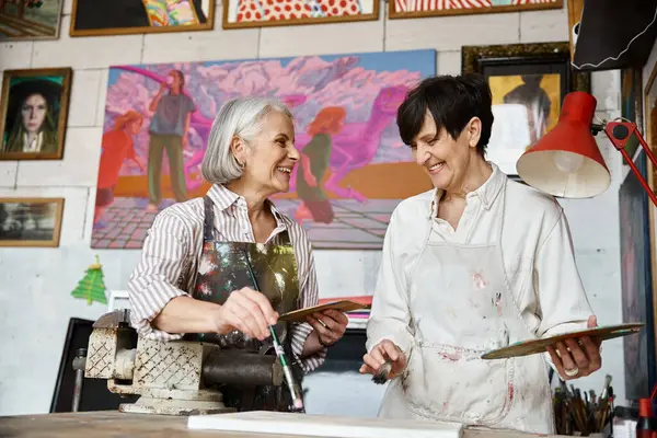 Two women share a moment in art studio. — Stock Photo