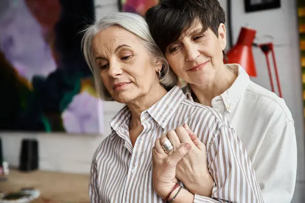 Two women embraceing in a cozy room. — Stock Photo