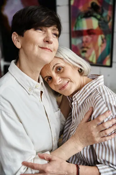 Two women in front of vibrant paintings. — Stock Photo