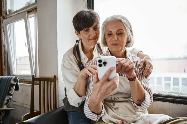 Two women using her phone to take a picture. — Stock Photo