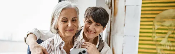 Two women taking a self-portrait with smartphone. — Stock Photo
