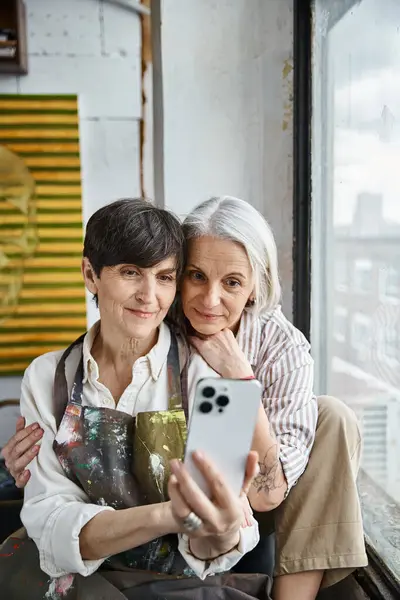Zwei Frauen posieren für ein Selfie in einem Kunststudio. — Stockfoto