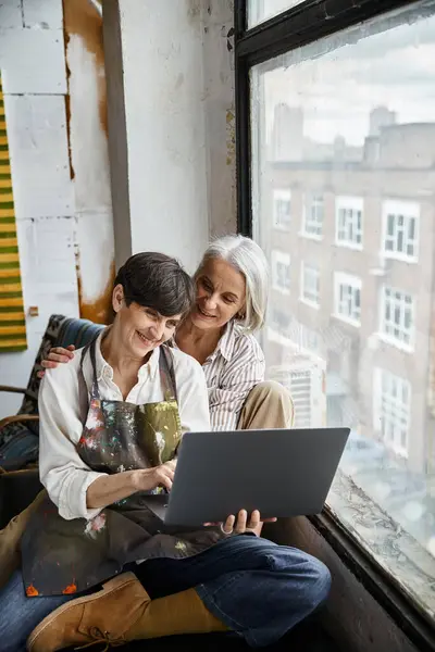 Mature lesbian couple absorbed in laptop screen. — Stock Photo