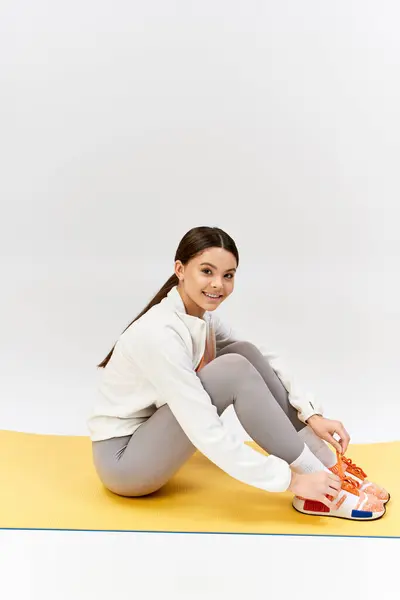 A serene girl with crossed legs on the mat, expressing calmness and stability. — Stock Photo