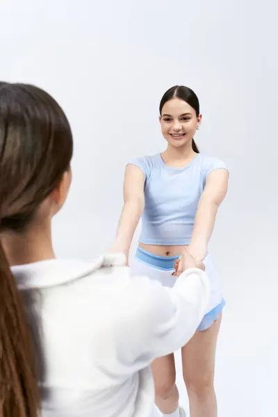 Une femme brune dans un haut bleu et une jupe se tient devant un ami — Photo de stock