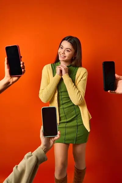 Дівчина-підліток перед групою людей, що тримають мобільні телефони. — стокове фото