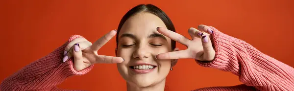 Una adolescente morena vestida con un atuendo casual sostiene sus manos frente a sus ojos, creando un efecto velo. - foto de stock