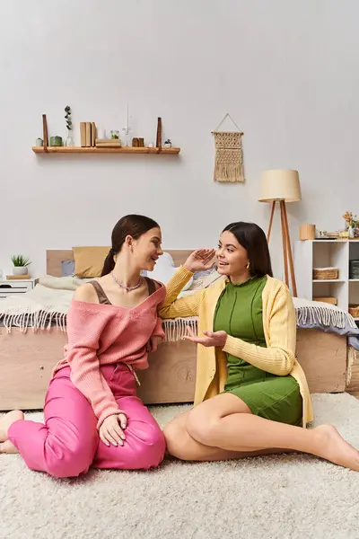 Zwei Mädchen im Teenageralter in lässiger Kleidung sitzen auf dem Boden und führen zu Hause ein tiefes Gespräch. — Stockfoto