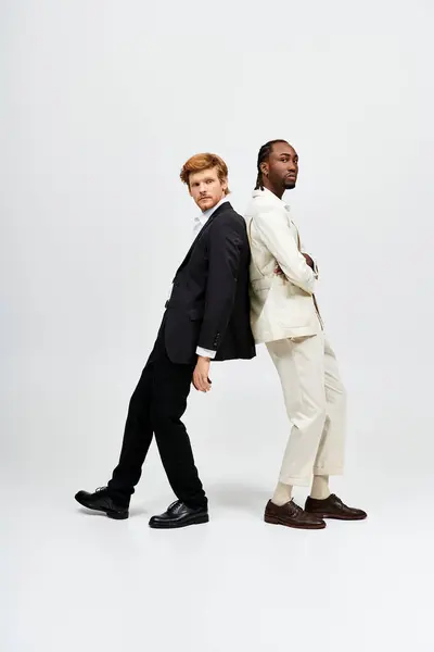 Two multicultural men in elegant suits pose together. — Stock Photo