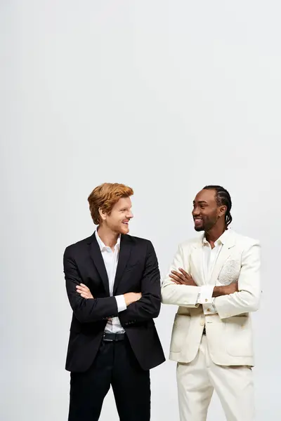 Two handsome men in suits pose elegantly together. — Stock Photo