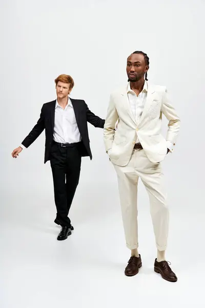 Two handsome multicultural men in stylish suits standing confidently side by side. — Stock Photo