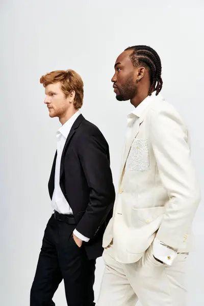Two handsome multicultural men in stylish suits walking together. — Stock Photo