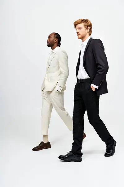 Two multicultural men in suits and ties walking side by side. — Stock Photo