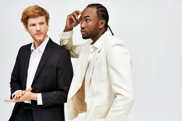 Two handsome multicultural men in stylish suits standing together. — Stock Photo