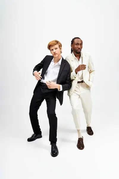 Due uomini multiculturali in abiti eleganti in posa con fiducia per la fotocamera. — Foto stock