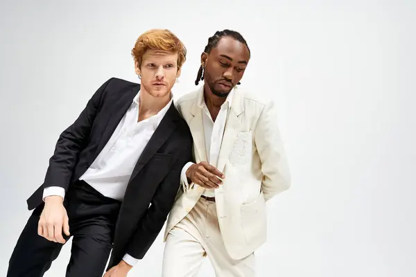 Two multicultural men in sharp suits striking a confident pose. — Stock Photo