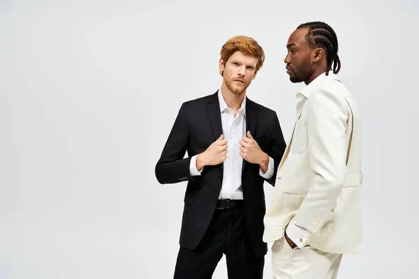 Two handsome multicultural men in stylish suits stand side by side. — Stock Photo