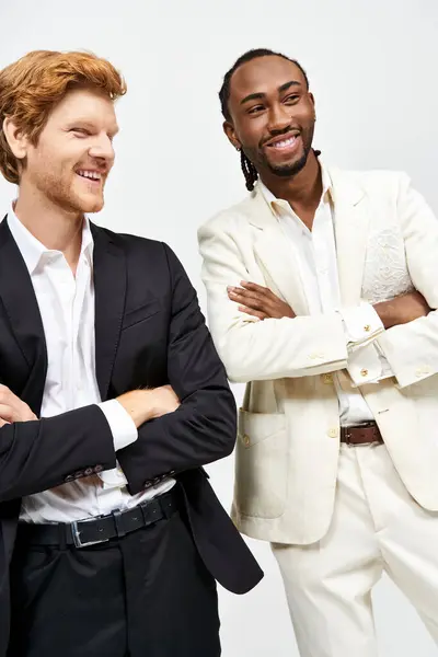Two handsome men in elegant suits standing side by side in a sophisticated pose. — Stock Photo