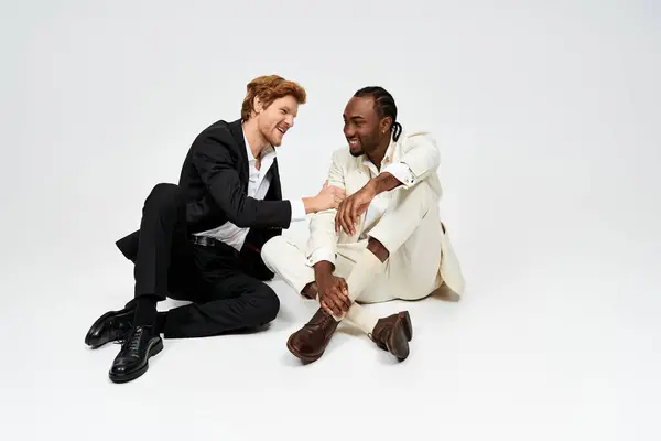 Дві багатокультурні особи, що сидять на землі в єдності. — стокове фото