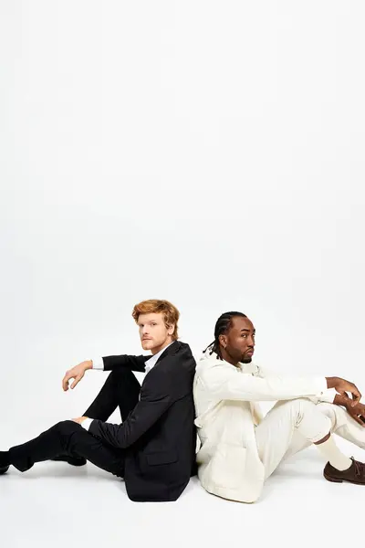 Dois homens multiculturais com estilo dapper sentam-se juntos no chão. — Fotografia de Stock