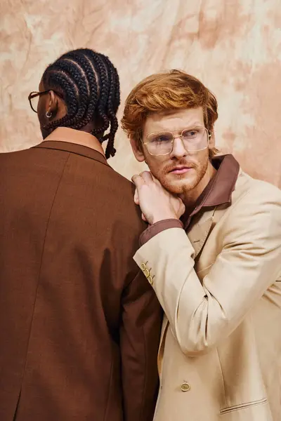 Multicultural men in glasses and trench coats strike a pose together. — Stock Photo