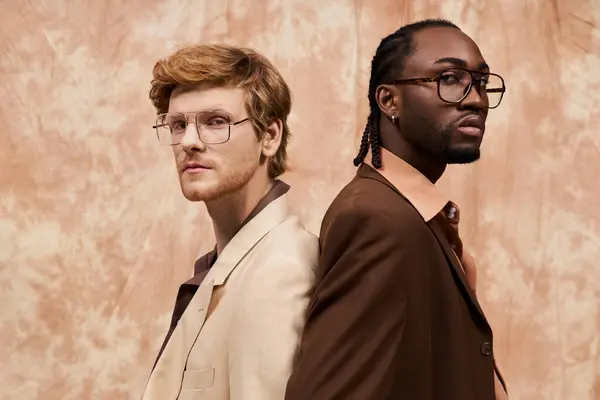 Two multicultural men with dapper style standing by a wall. — Stock Photo