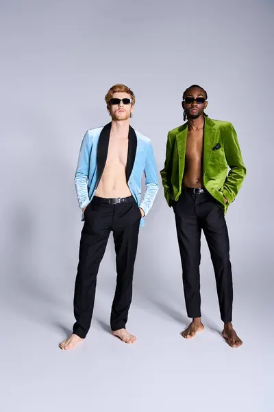 Two handsome multicultural men with elegant dapper style stand side by side in front of a gray background. — Stock Photo