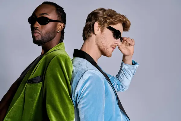 Two multicultural men in green jackets strike a pose in stylish sunglasses. — Stock Photo