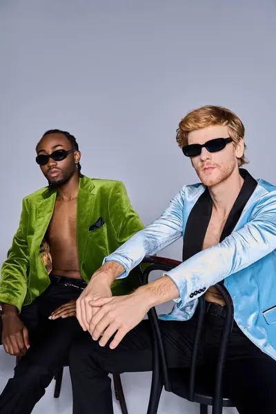 Two handsome multicultural men in elegant attire sitting side by side. — Stock Photo