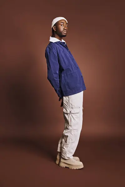 Un bel giovane afroamericano in giacca blu e pantaloni bianchi. — Foto stock