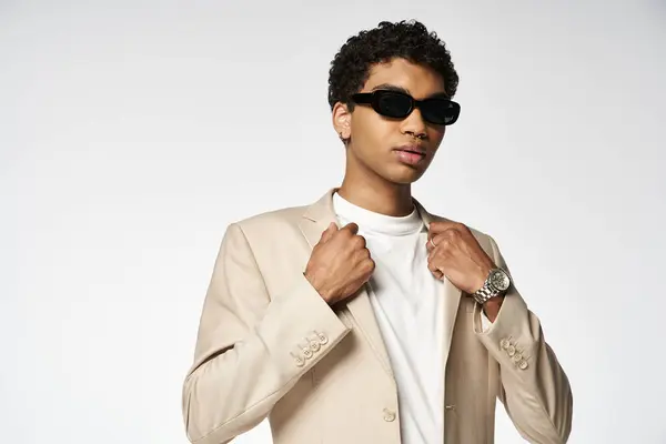 Schöner afroamerikanischer Mann mit Sonnenbrille und schickem braunen Anzug. — Stockfoto