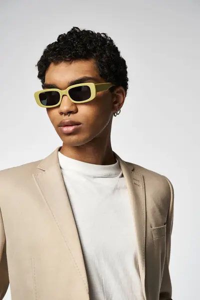 Dapper homem afro-americano em terno bronzeado e óculos de sol amarelos elegantes. — Fotografia de Stock