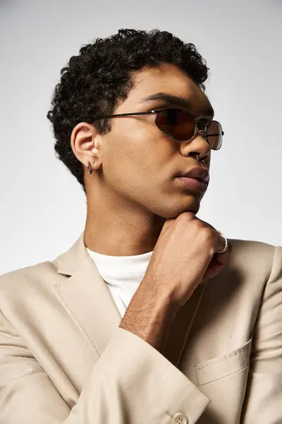 Elegante hombre afroamericano con gafas de sol y un traje de bronceado. — Stock Photo