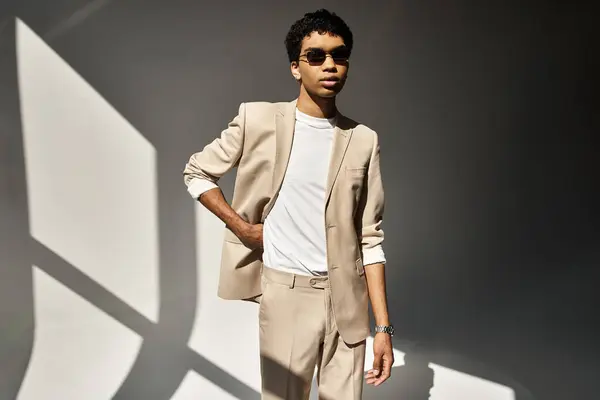 Bonito homem afro-americano olhando elegante em um terno bege e óculos de sol. — Fotografia de Stock