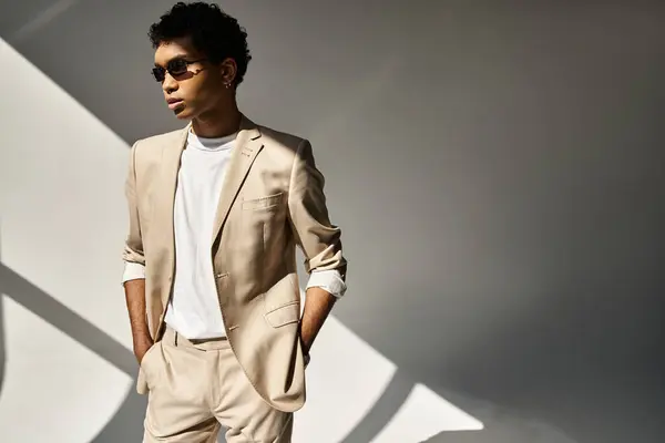 Handsome African American man in tan suit and sunglasses strikes a confident pose. — Stock Photo