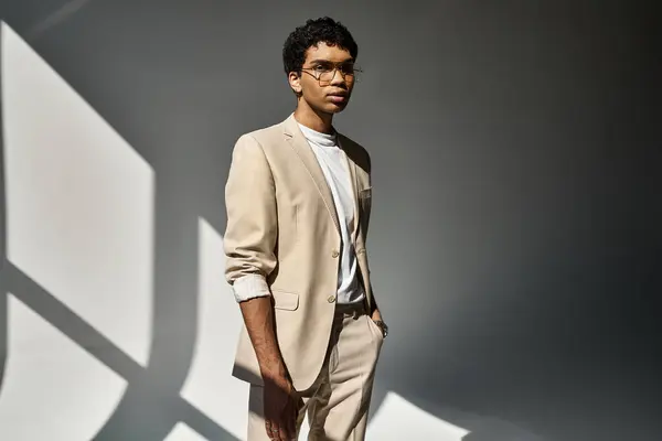 Bonito homem afro-americano em terno bronzeado e óculos de sol marcando uma pose confiante — Stock Photo