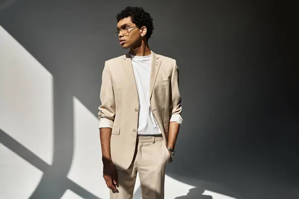 Handsome African American man in stylish sunglasses standing in front of a white wall. — Stock Photo