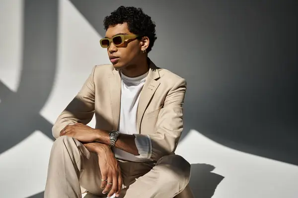 A stylish young African American man in a beige suit and fashionable sunglasses. — Stock Photo
