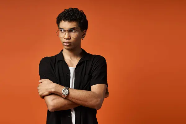 Handsome African American man wearing stylish glasses poses confidently against a vibrant orange background. — Stock Photo