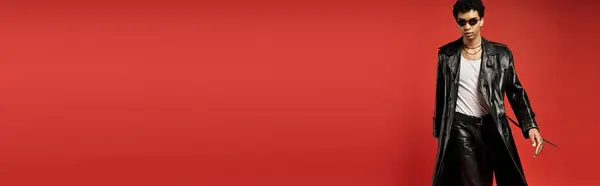 Handsome African American man in sunglasses standing in front of a red background. — Stock Photo