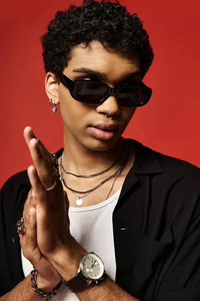 Jeune Afro-Américain en chemise noire portant avec confiance des lunettes de soleil. — Photo de stock
