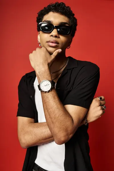 Handsome African American man in sunglasses posing with hand on chin. — Stock Photo