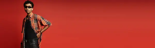 African American man in sunglasses posing against vibrant red wall. — Stock Photo