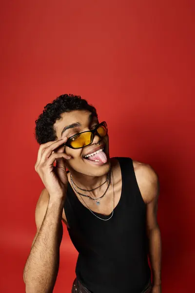 Красивий афроамериканський чоловік з сонцезахисними окулярами, грайливо стирчить язиком. — стокове фото