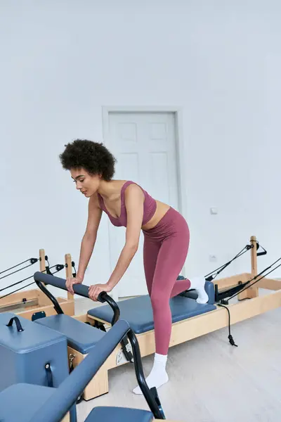 Donna attiva in top rosa e leggings in esecuzione sul tapis roulant. — Foto stock