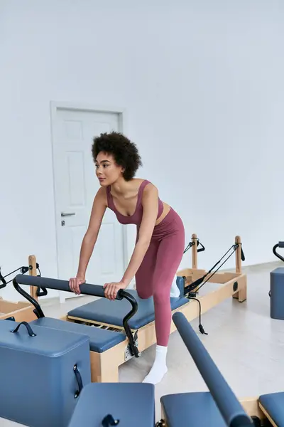 A woman gracefully performs pivots on a rowing machine. — Stock Photo