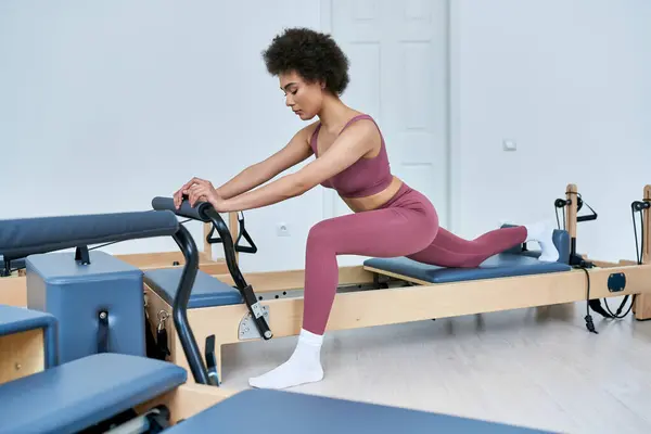 Eine Frau in rosa Oberteil und Leggings macht energisch Sport. — Stockfoto