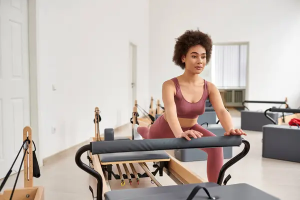 Una mujer haciendo ejercicio, centrándose en su rutina de ejercicios. - foto de stock