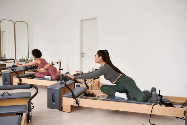 Athletic woman is intensively exercising next to her friend. — Stock Photo